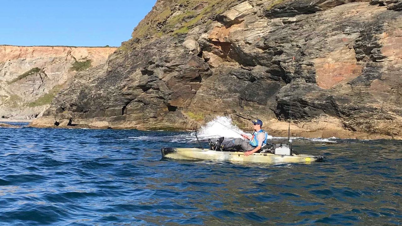Kayak fishing around a rocky headland for wrasse
